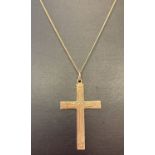 A 9ct gold cross pendant on an 18" fine curb chain. Engraved detail to front of cross.