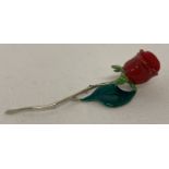 A small enamelled silver pin cushion in the shape of a rose.