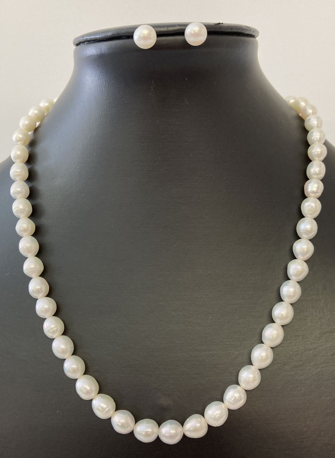 A freshwater white pearl necklace and matching stud earrings.