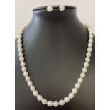 A freshwater white pearl necklace and matching stud earrings.