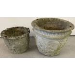 2 concrete circular planters with floral decoration to outside.