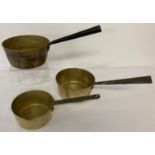 2 vintage brass pouring pans together with a brass saucepan.