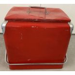 A large vintage American drinks cooler, painted red.