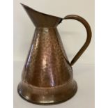 A large vintage copper jug with hammered effect detail.