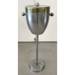 A vintage aluminium and brass effect hotel champagne/ice bucket on a pedestal stand.