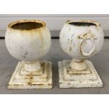 2 small vintage cast iron urns on stepped bases. Painted white.