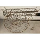 A vintage wirework plantstand in the shape of a decorative barrow.