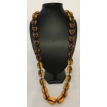 A 34" beaded necklace with large oval shaped amber style beads.