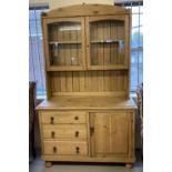 A vintage pine double dresser with glass fronted doors to top.