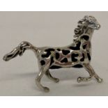 A small sterling silver horse shaped pin cushion with pierced work detail and blue velvet cushion.