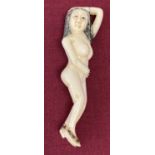 A small carved bone figure of a naked lady.
