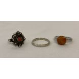 3 silver and white metal dress rings. An orange jade solitaire and a twist design band.