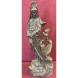 A vintage hollow metal Chinese figurine of an Oriental deity & child riding a dragon.