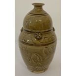 A slim necked brown/yellow glaze ceramic vase with fish and lotus flower detail.