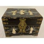 A vintage Oriental black lacquer, brass banded box with mother of pearl figural detail in relief.