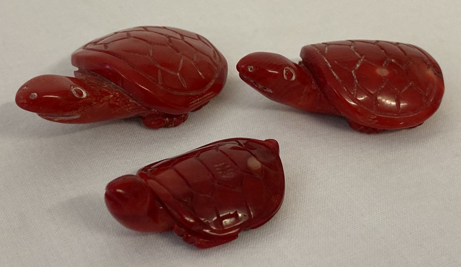 3 small carved coral figures in the shape of tortoises/turtles.