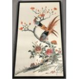 A framed and glazed embroidered silk panel of oriental pheasants in a tree.