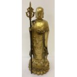 A gilt hollow bronze figure of an Oriental Deity holding a staff stood atop a lotus flower.