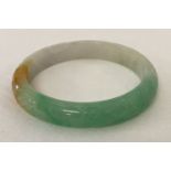 A small jade bangle with engraved detail.