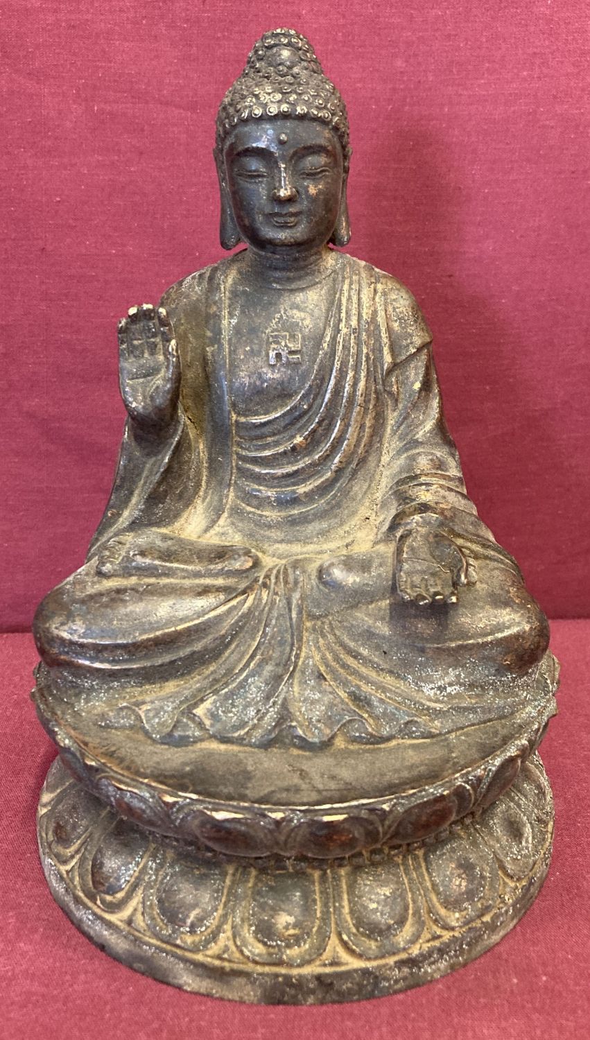 A circular based hollow bronze figure of seated Buddha atop a lotus flower.