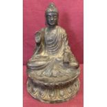 A circular based hollow bronze figure of seated Buddha atop a lotus flower.