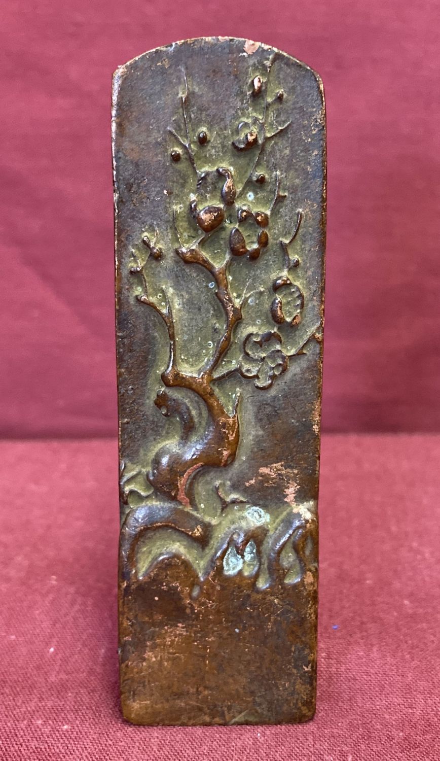 A small Chinese bronze seal featuring Cherry blossom tree detail.