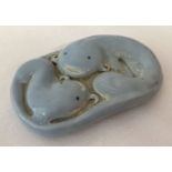 A blue porcelain Chinese scroll weight depicting fish.