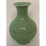 A green glazed Chinese ceramic vase of bulbous form with wide lipped neck.