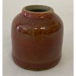 A small Chinese ceramic brush pot with orange speckled glaze.