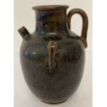 A brown ceramic 3 handled, small spouted urn with black speckled glaze.