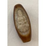 A carved agate bead depicting an Oriental Deity.