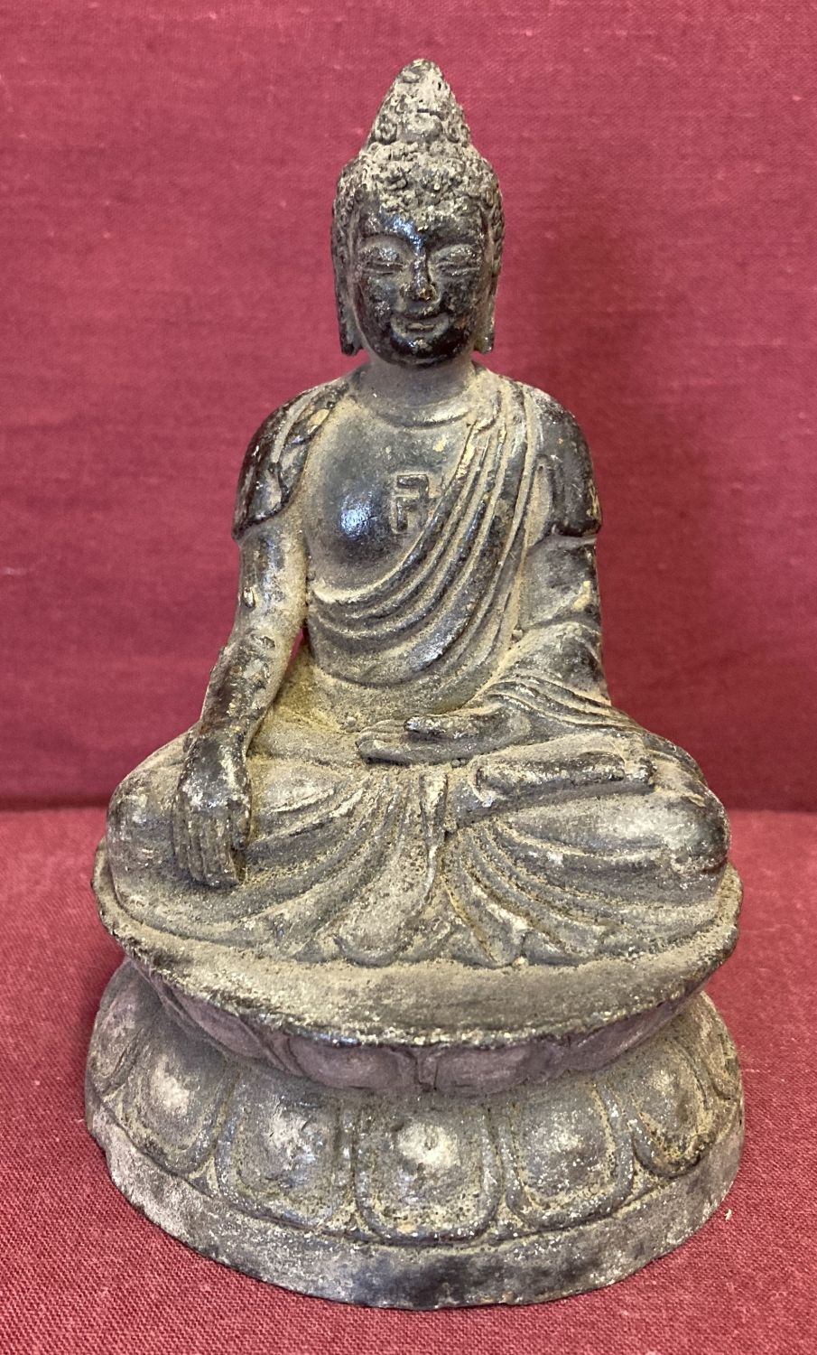 A small circular based hollow bronze figure of seated Buddha.