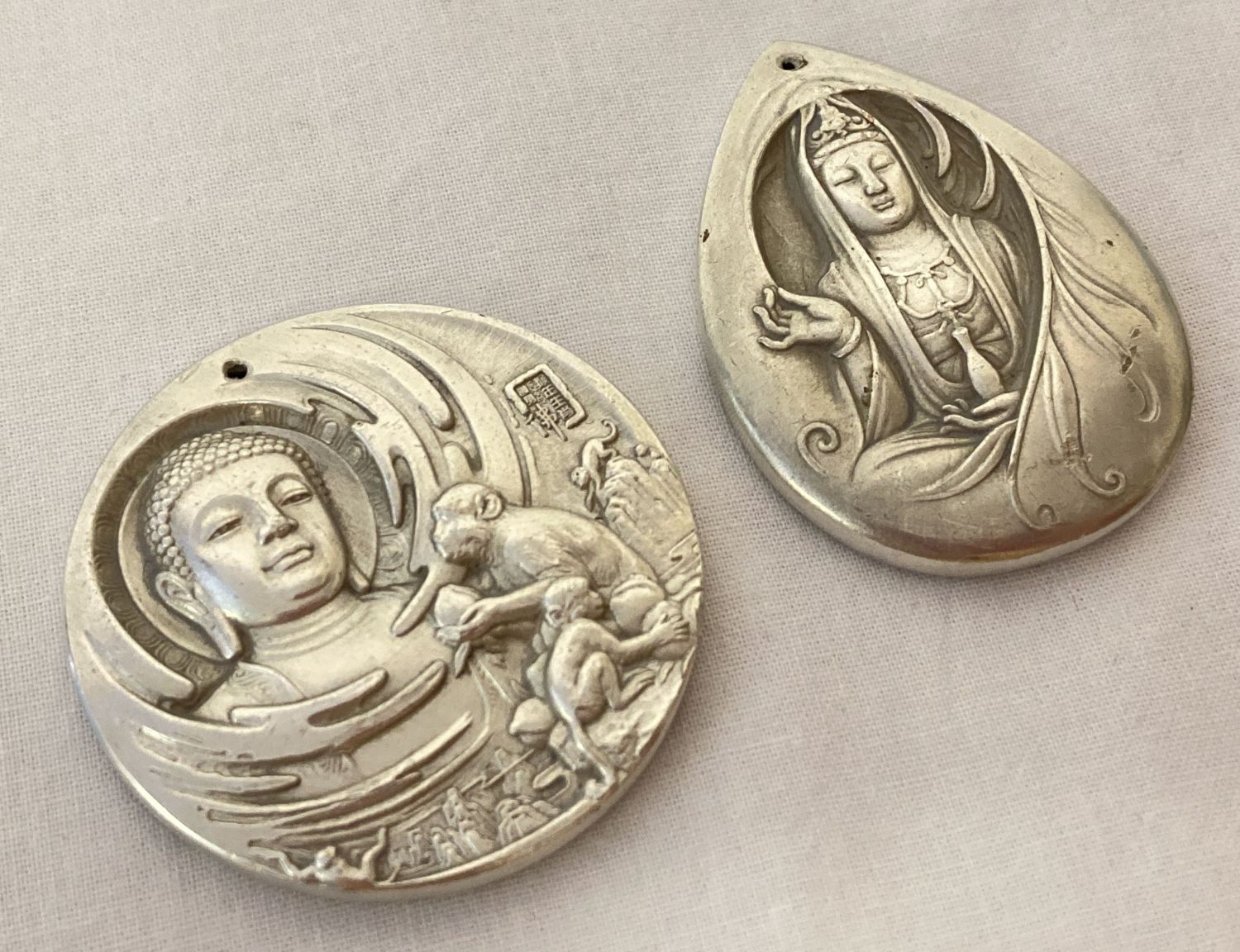 2 Chinese white metal, double sided pendants depicting Oriental Deities.