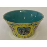 A small Chinese ceramic tea bowl with colourful floral detail and panel design to outer bowl.