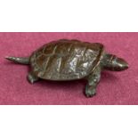 A small Chinese bronze figure of a turtle, signed to underside.
