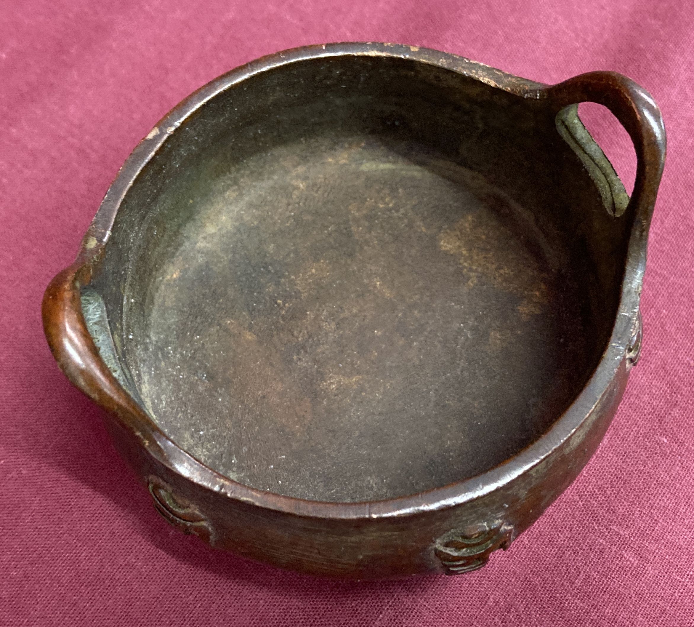 A small bronze 2 handled censer, raised on tripod feet & with calligraphy detail to outer bowl. - Image 3 of 4