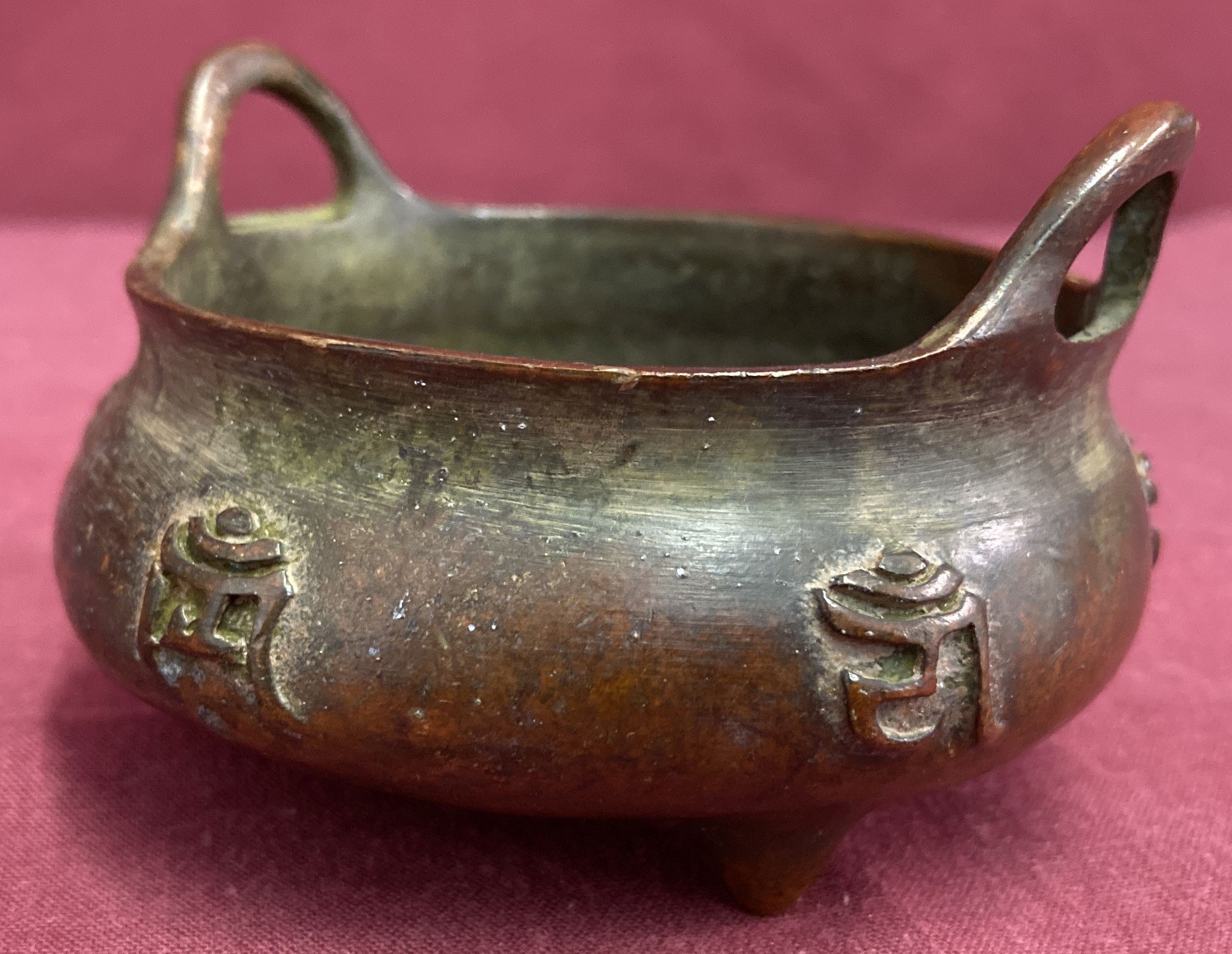 A small bronze 2 handled censer, raised on tripod feet & with calligraphy detail to outer bowl. - Image 4 of 4