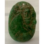 A carved Chinese green jade pendant.