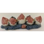 A hand painted ceramic brush rest in the form of 5 peaches.