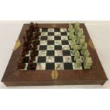 A wooden cased oriental design chess set with brass hinges, plates and handles.