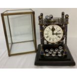 A skeleton movement rolling ball table clock with cloisonné posts and finials.