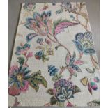 A modern floral design wool rug "Iris", with cream ground and pink, green and blue colourway.