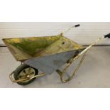 A vintage tip action metal wheelbarrow with rubber tyre and grip handles.