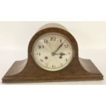 A vintage dark oak cased Napoleons hat mantel clock with striking action.