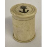 A small circular shaped carved bone, scrimshaw style lidded pot.