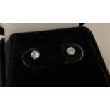 A pair of boxed 9ct gold stud style earrings set with pale blue stones, possibly blue topaz.