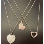 3 silver and white metal heart design necklaces.