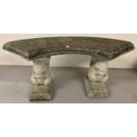 A concrete ornamental garden bench with curved seat and squirrel pedestal supports.