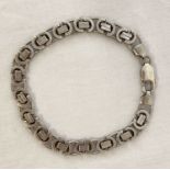 A decorative chain link silver bracelet with lobster style clasp.