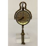 A brass bound ball watch pendant with tassel detail.